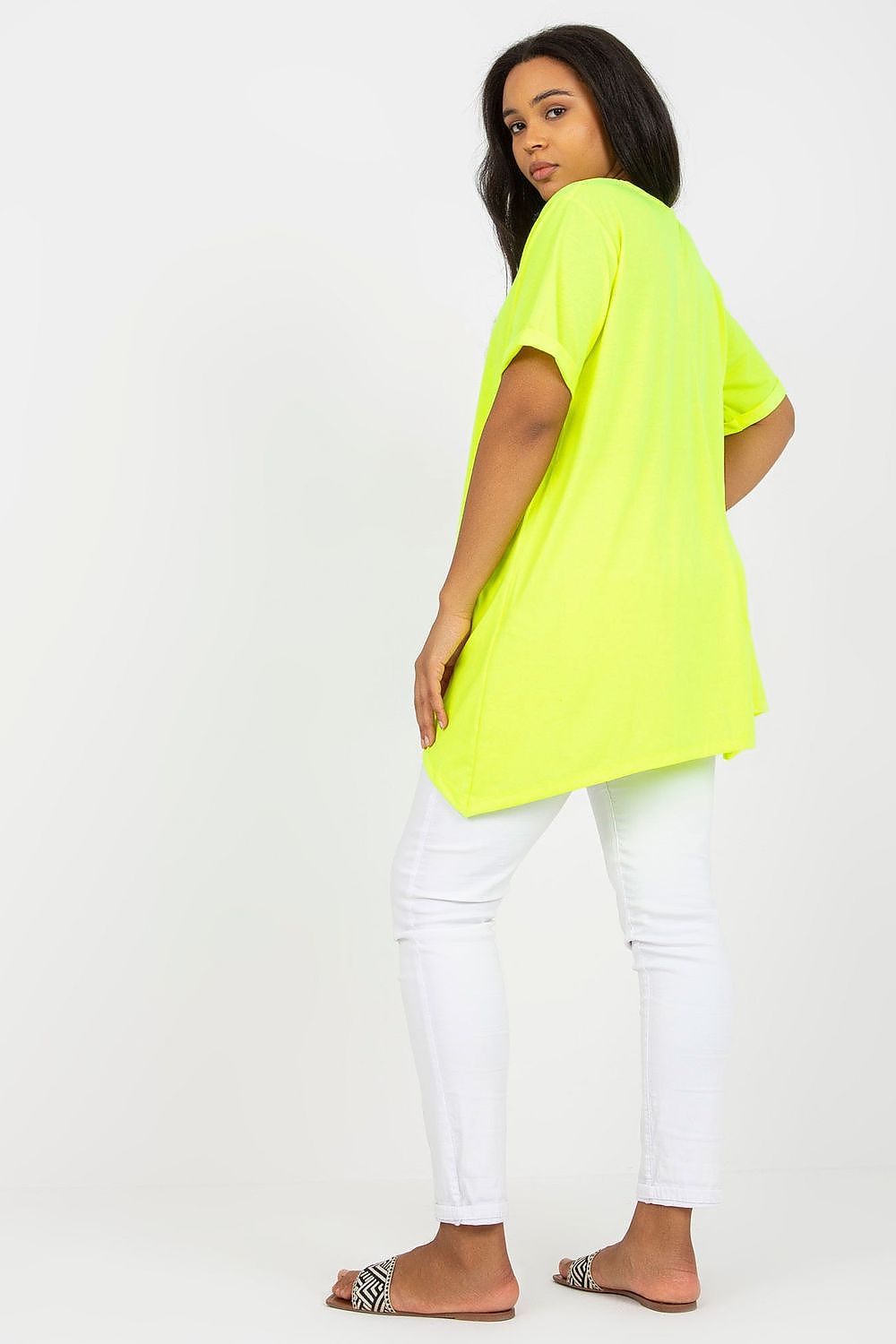 Stylish Plus Size Tunic with Short Sleeves and Asymmetrical Hemline - Boat Neck Design, viewed from the back, highlighting the flowing silhouette and neon yellow hue, styled elegantly with white pants.