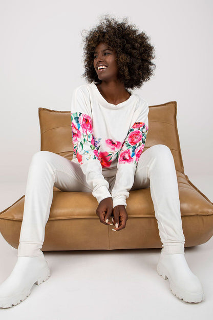 Chic Rue Paris 2-Piece Set featuring a stylish long sleeve sweatshirt adorned with vibrant floral patterns and tailored long pants, elegantly styled on a model seated comfortably.