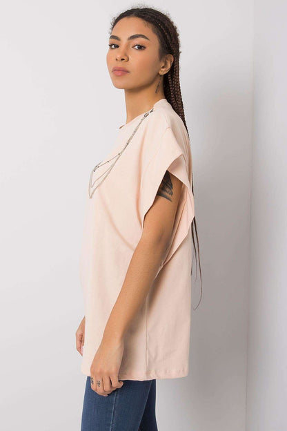 Side view of the Rue Paris Luxurious Loose Fit Blouse in soft pink, highlighting its relaxed silhouette and stylish design, complemented by a detachable chain detail.