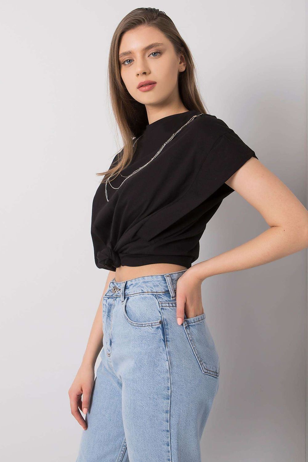 Side view of the Rue Paris Luxurious Loose Fit Blouse with Short Sleeves & Detachable Chain, featuring a chic design and paired with high-waisted jeans, perfect for a luxury casual look.
