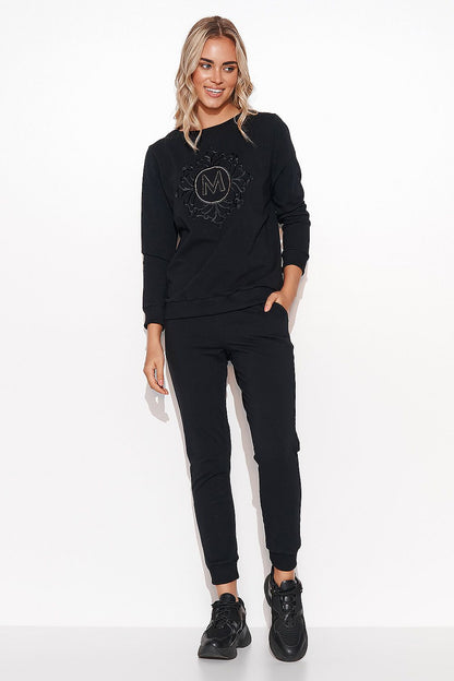Elegant Women's Makadamia Sweatshirt Set with Crystal Detail and Comfortable Long Pants, model in a chic black sweatshirt with intricate details and complementary black trousers.