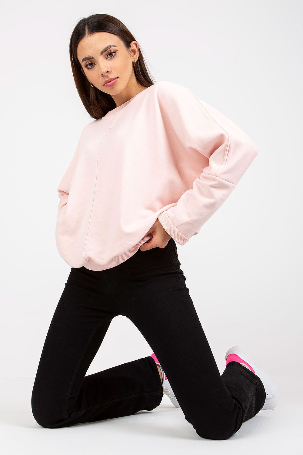Stylish women's loose fit cotton spandex sweatshirt with round neckline by Rue Paris, elegantly showcased in soft pink, perfect for casual luxe wear. The model pairs it with sleek black jeans, highlighting its trendy design.