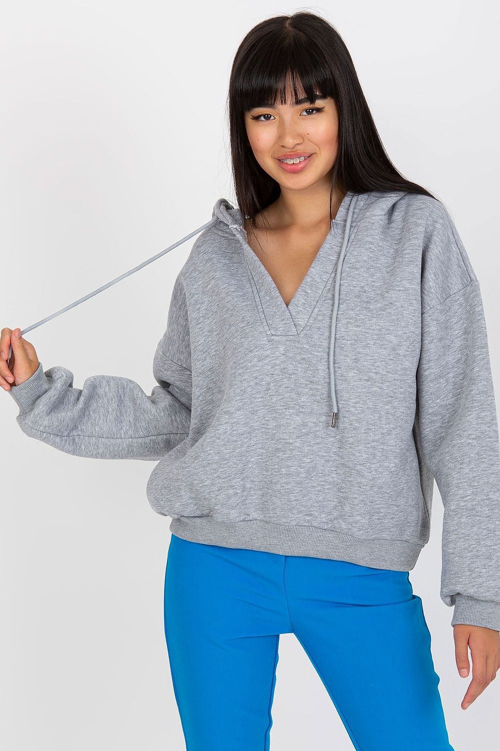 Luxury Women's V-Neck Sweatshirt With Hood - Premium Cotton Blend By BFG, showcased on a model wearing a stylish grey hoodie with a v-neck and ties, paired with vibrant blue trousers, exemplifying comfort and modern fashion.