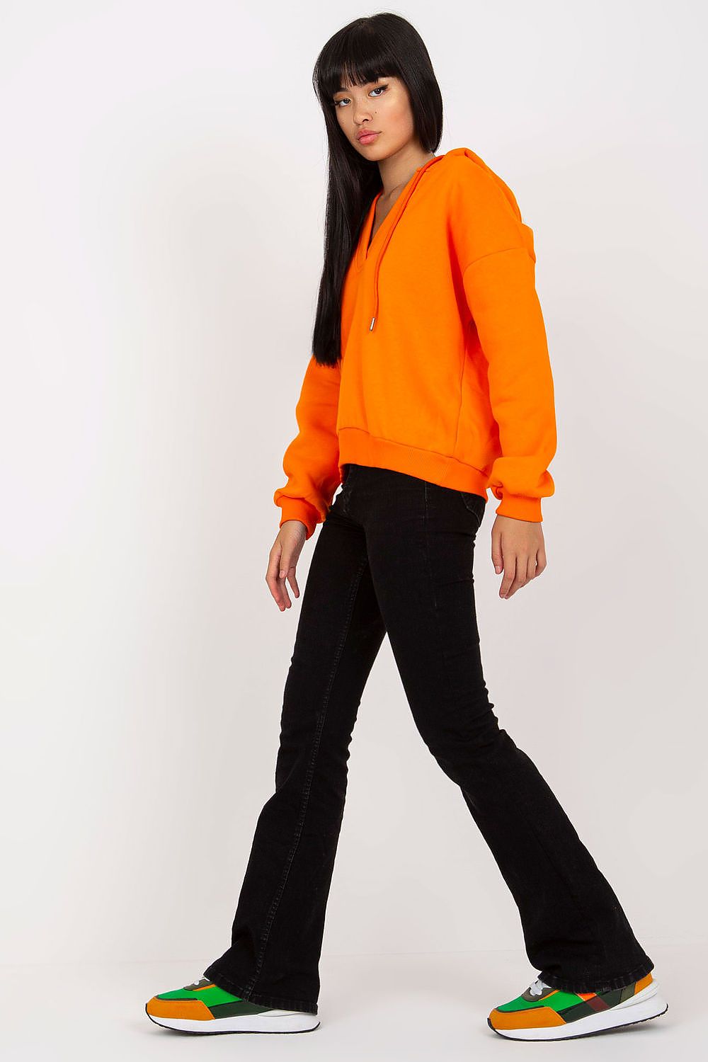 Luxury Women's V-Neck Sweatshirt With Hood - Premium Cotton Blend By BFG, featuring an orange hooded sweatshirt styled with black flared pants, exuding a trendy vibe.