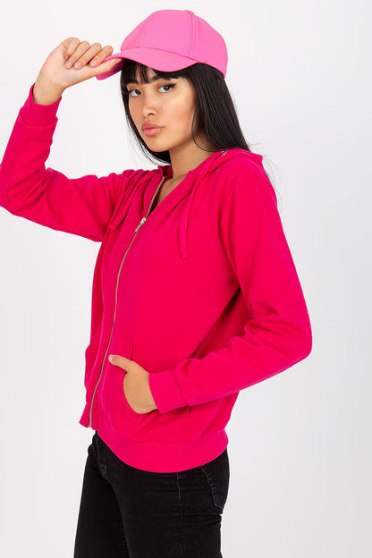 Elevate your style with the Women’s Luxury Hooded Zippered Sweatshirt with Front Pockets - BFG. A model showcases this pink cotton-blend sweatshirt, ideal for casual elegance.