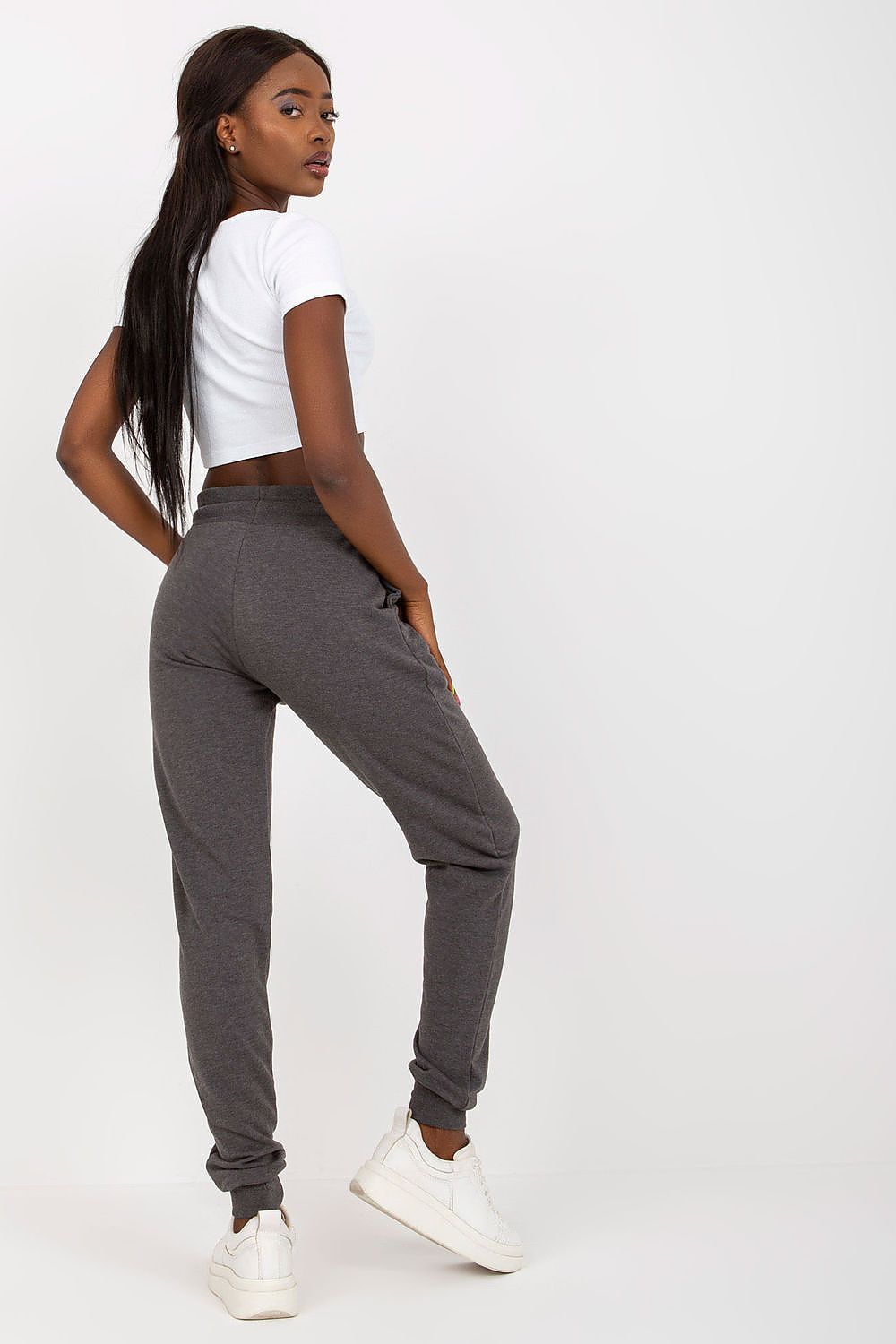 Elegant model showcasing BFG High-Waisted Tracksuit Trousers with Elastic Waistband and Side Slip Pockets in a chic grey colour, styled with a white crop top.