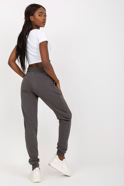 Elegant model showcasing BFG High-Waisted Tracksuit Trousers with Elastic Waistband and Side Slip Pockets in a chic grey colour, styled with a white crop top.
