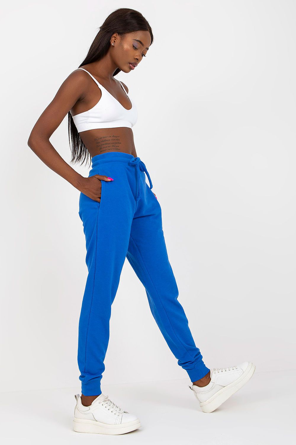 BFG High-Waisted Tracksuit Trousers with Elastic Waistband and Side Slip Pockets featuring a model in vibrant blue trousers, exuding elegance while expertly styling her look with a chic white crop top.