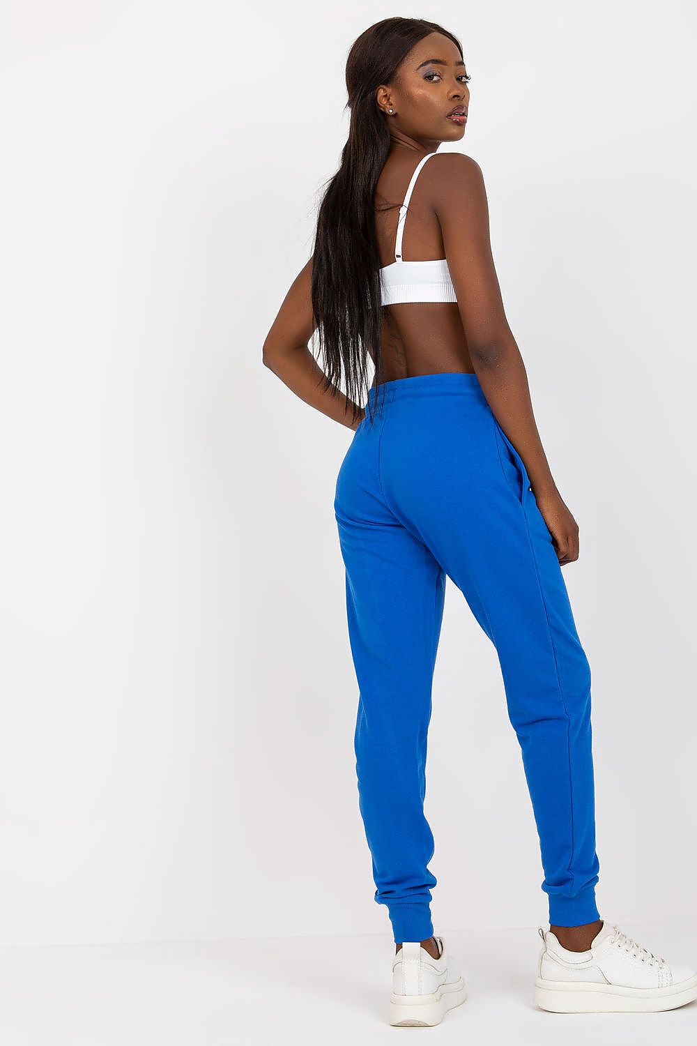 BFG High-Waisted Tracksuit Trousers with Elastic Waistband and Side Slip Pockets illustrated on a model, showcasing the back view in luxurious blue tones, combined with a simple white top and contemporary footwear.