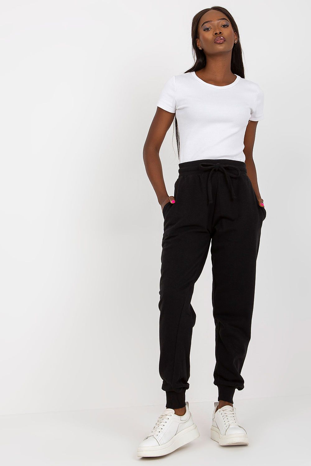 Front view of a model wearing the BFG High-Waisted Tracksuit Trousers in black, complemented by a classic white t-shirt, presenting a trendy and luxurious look.