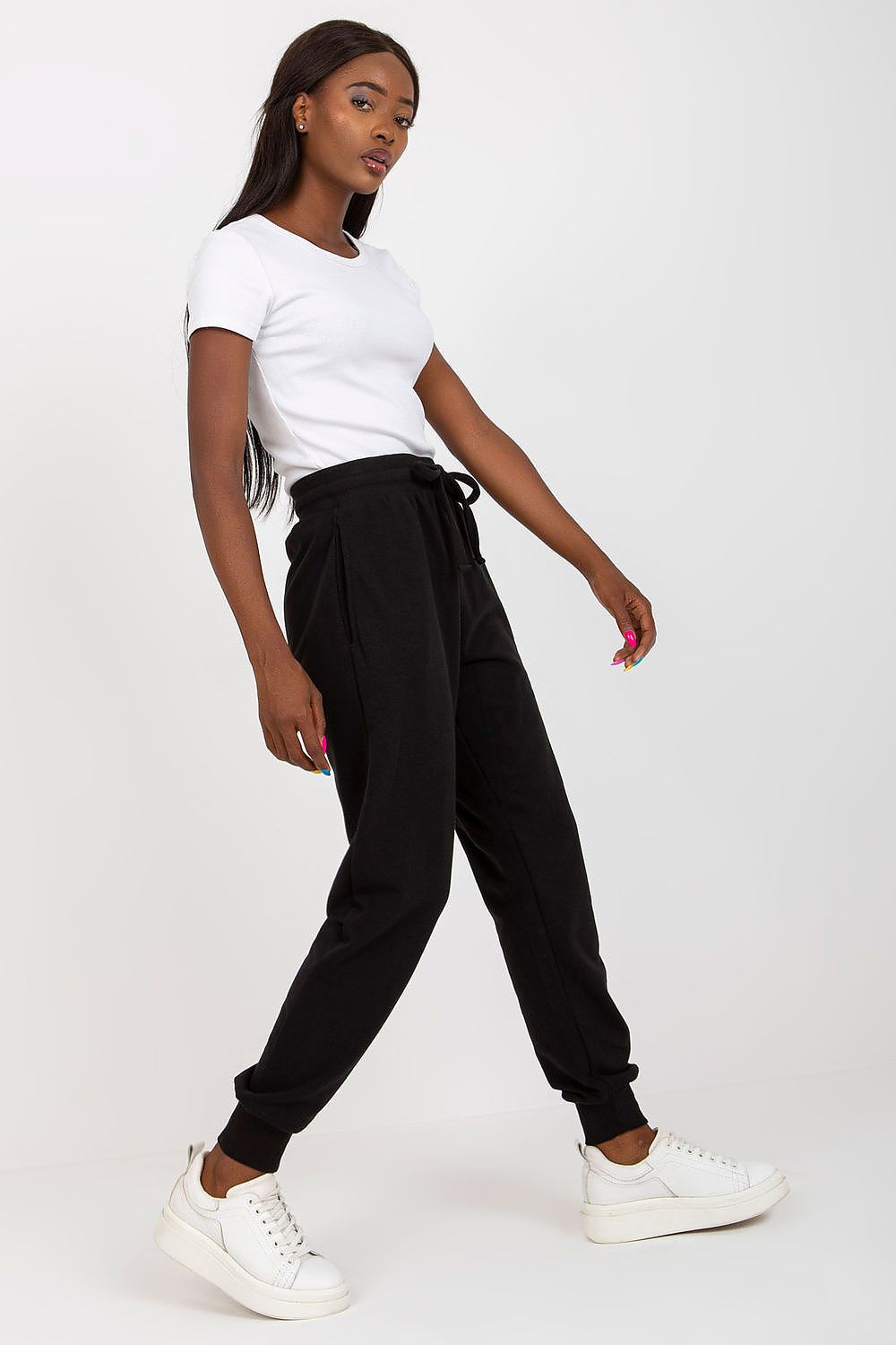 Stylish side perspective of BFG High-Waisted Tracksuit Trousers in black, paired with a white t-shirt, reflecting sophistication and comfort.