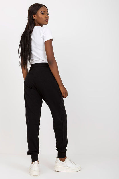 Back view of the BFG High-Waisted Tracksuit Trousers in black, illustrating the sophisticated design and elastic waistband, styled with a fitted white t-shirt.