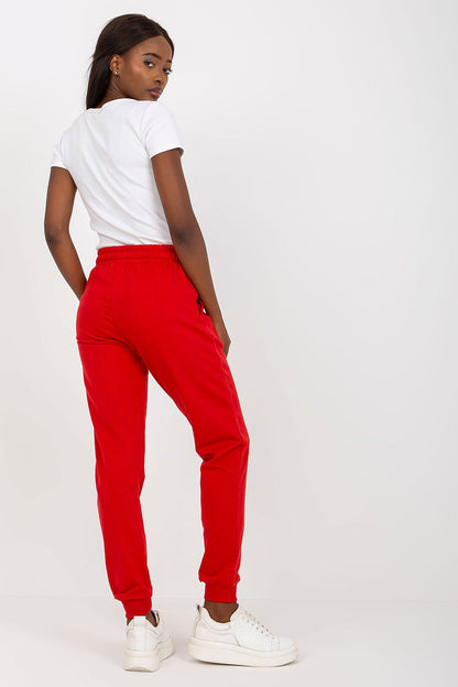 Sophisticated side view of a model in BFG red high-waisted sweatpants with elastic waistband and side pockets, accentuating modern streetwear style.