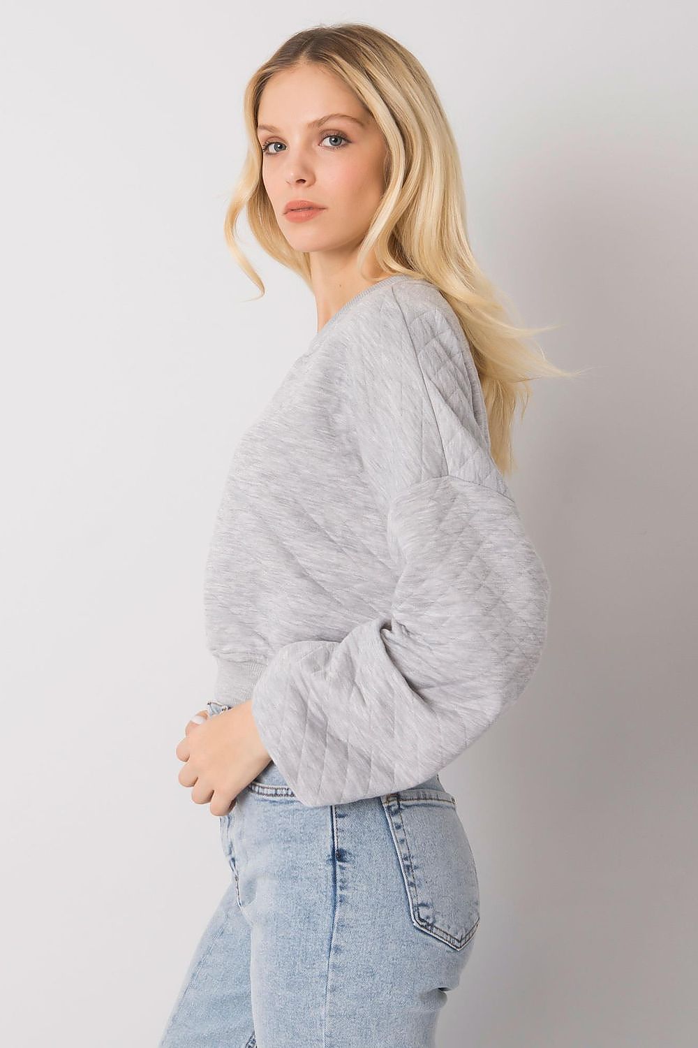 Elegant BFG Quilted Fabric Sweatshirt with Ribbed Hem – Long Sleeves, Perfect for Casual Chic. A woman in a light grey quilted sweatshirt styled with high-waisted jeans, exuding an effortless elegance.