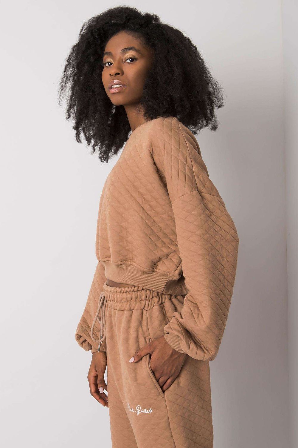 Elegant BFG Quilted Fabric Sweatshirt with Ribbed Hem – Long Sleeves, Perfect for Casual Chic. A woman is seen in a stylish profile view wearing a brown quilted sweatshirt, emphasizing casual sophistication.