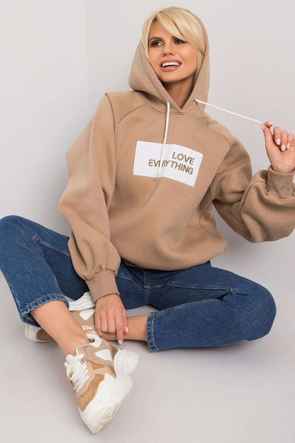 Ex Moda Women's Hooded Sweatshirt - Chic long sleeve design featuring decorative inscription, styled with relaxed jeans and sneakers.