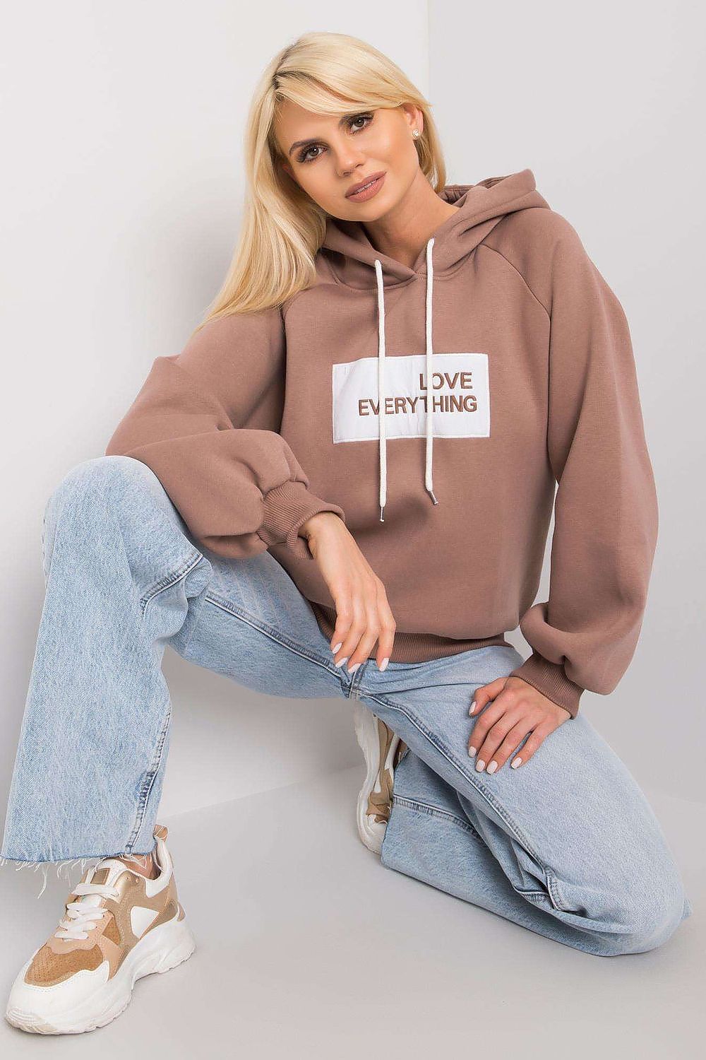 Ex Moda Women's Hooded Sweatshirt - Trendy long sleeve hoodie with a chic decorative message, styled with relaxed-fit denim for a contemporary vibe.