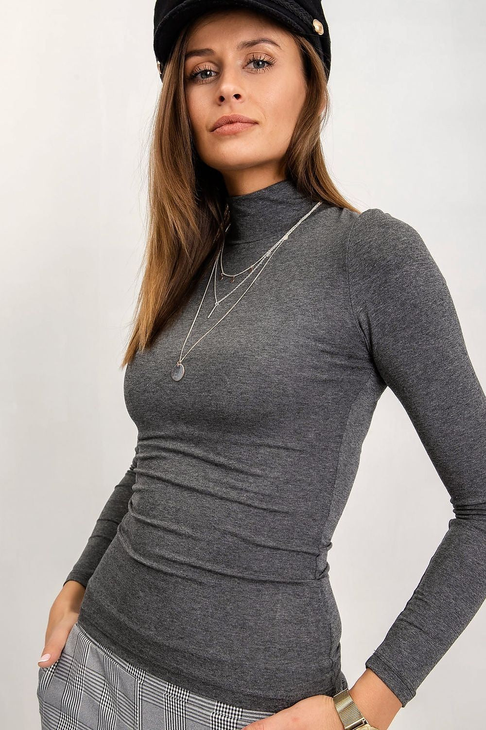 Elegant woman in a luxurious long-sleeve turtleneck by Rue Paris in grey, featuring chic accessories, exuding a refined sense of fashion.
