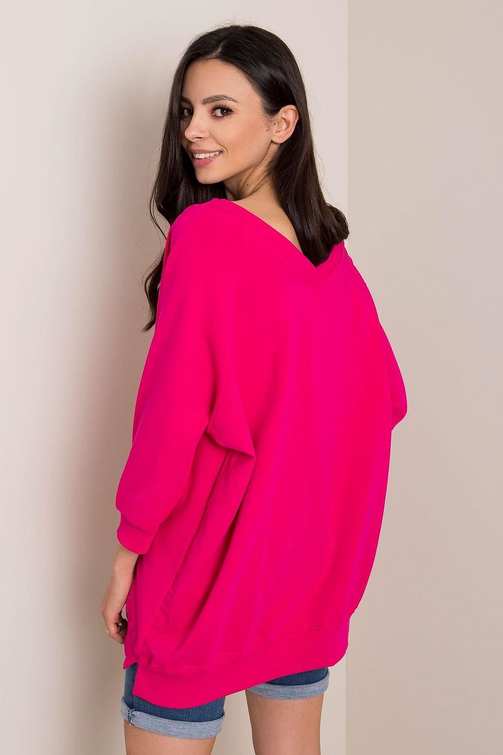 Fashionable Loose Fit Rue Paris Sweatshirt With Heart Neckline in radiant pink, model captured smiling while showcasing an elegant casual look, constructed from a soft cotton-spandex mix.