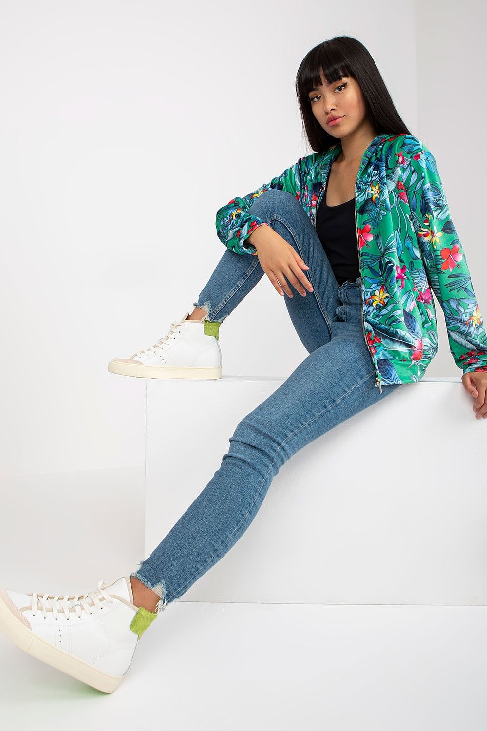 Luxury Rue Paris Women's Hooded Sweatshirt with Zip and Side Pockets – Elegant Long Sleeves, model wearing a vibrant floral hoodie paired with denim jeans and stylish sneakers.