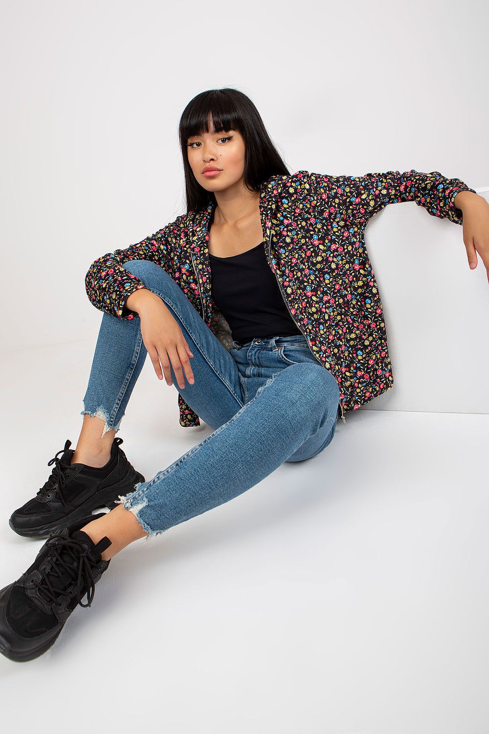 Stylish pose in Luxury Women's Long-Sleeved Zip-Up Sweatshirt by Rue Paris, with floral details, paired with distressed jeans and sneakers.