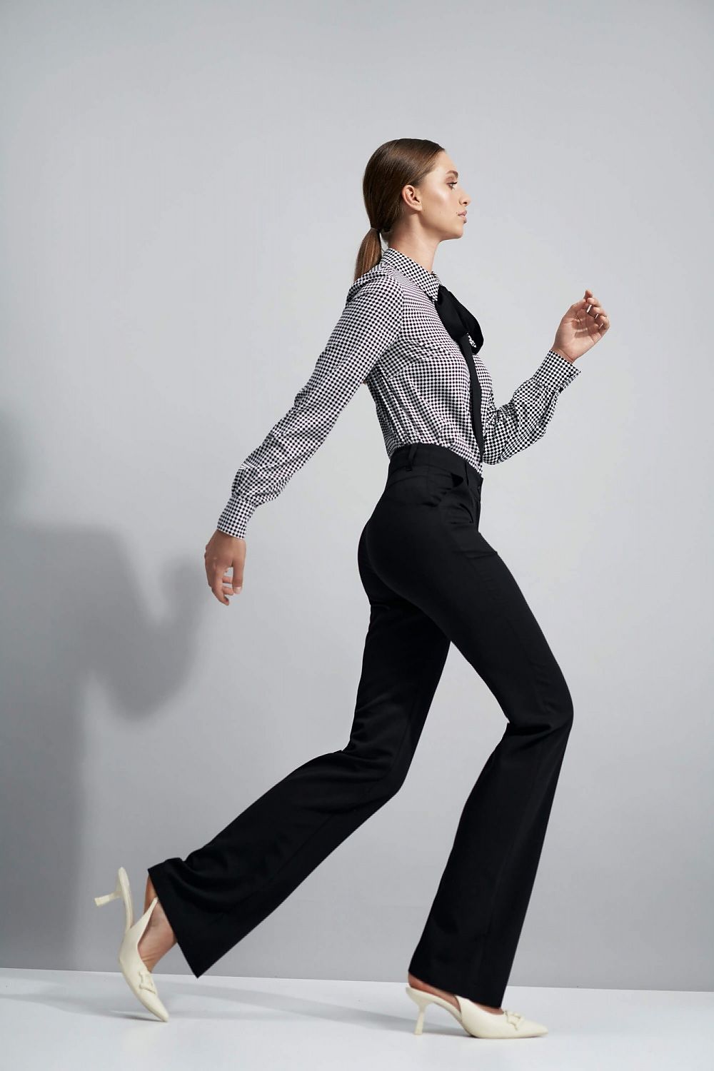 Side profile of Elegant Flared Trousers with Pepite Print, styled with a checked blouse, illustrating their versatility for both office and evening wear.