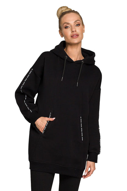 Moe Luxury Fleece-Lined Sweatshirt Tunic in elegant black, styled with a casual yet luxurious flair, featuring a hood and distinctive logo embellishments.
