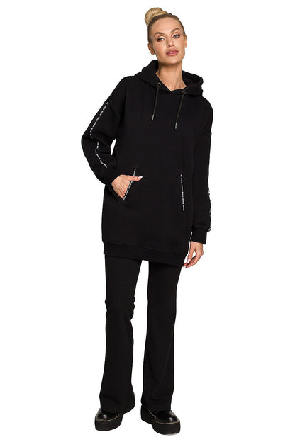 Moe Luxury Fleece-Lined Sweatshirt Tunic showcasing a chic woman wearing a stylish black sweatshirt with a hood and unique design, perfect for versatile styling as a dress or a longer top.