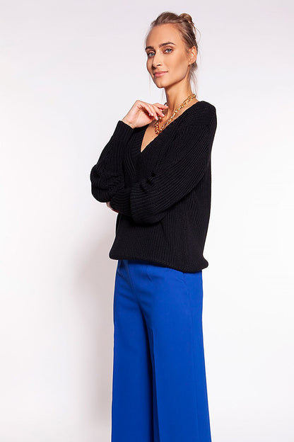 Luxurious Minimalist Ribbed Knit Jumper with Deep Heart Neckline by MKM, showcased in black, paired with royal blue trousers, highlighting its casual yet elegant style.
