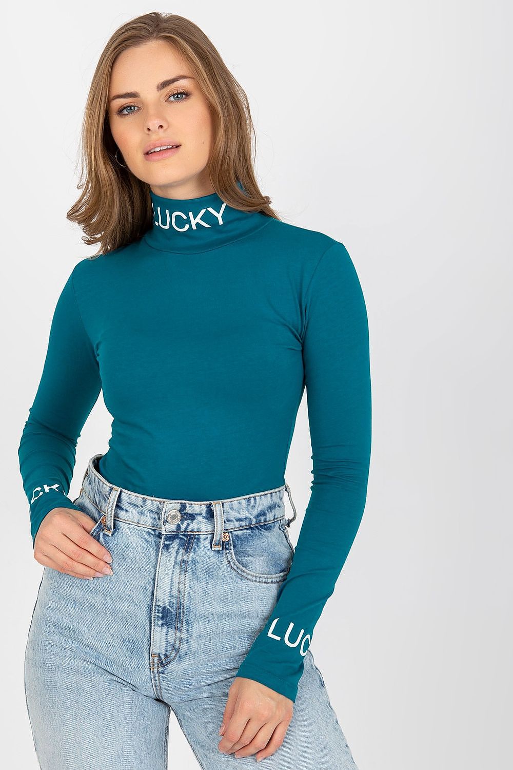 Refined portrait of a woman wearing the Elegant Cotton Blouse with Long Sleeves and Turtleneck by Ex Moda. The fitted design features striking contrast lettering and complements her effortless style with stylish high-waisted trousers.
