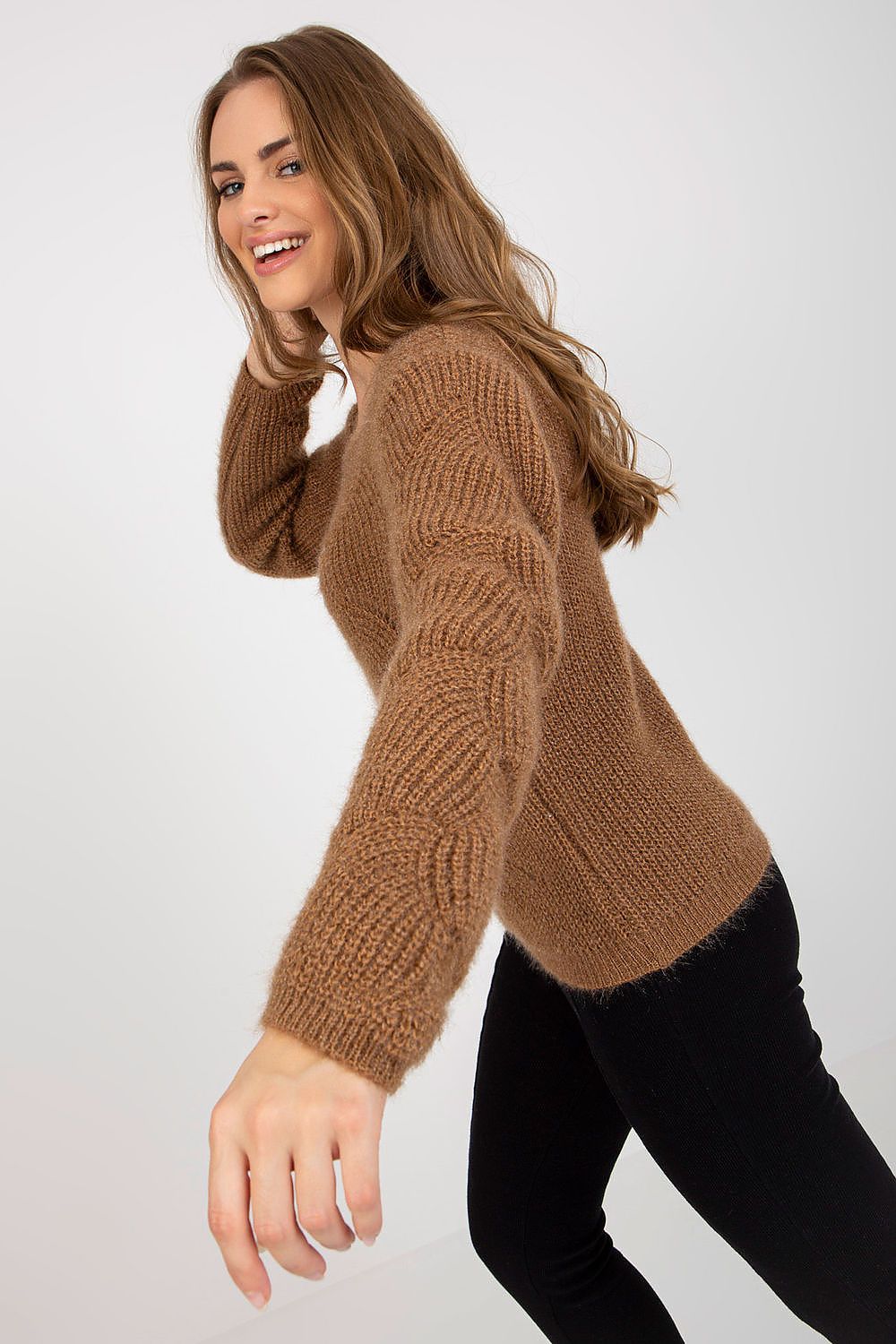 A dynamic pose of the model wearing the Och Bella Openwork Sweater with Long Sleeves and Boat Neckline, radiating elegance in soft brown knitwear, perfect for any occasion.
