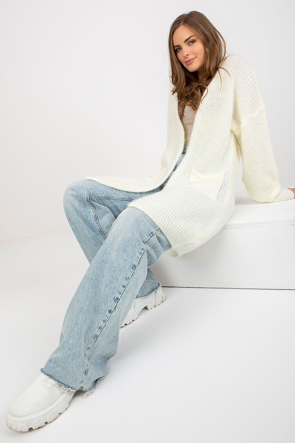 Luxury Unbuttoned Cardigan by Och Bella with Pockets featured on a seated model, highlighting the soft fabric blend, ideal for elegant layering.