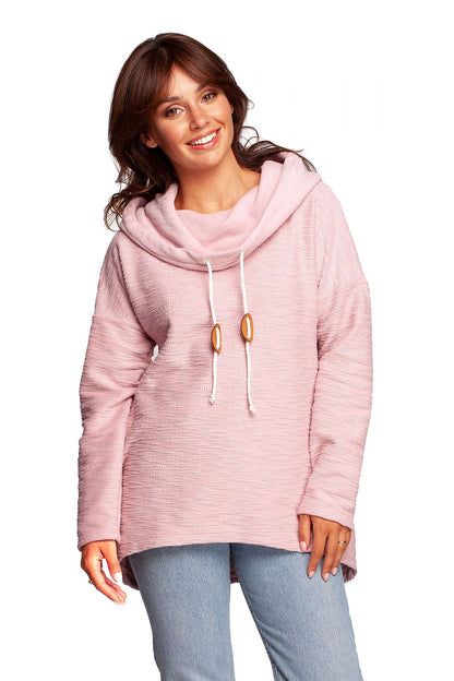 BeWear Oversized Cotton Blend Hooded Sweatshirt Tunic for Comfortable Cold Weather, model smiling radiantly in a soft pink tone, accentuating the chic design and elegant details of the tunic.