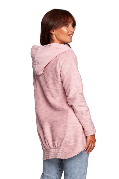 Elegant woman showcasing the BeWear Oversized Cotton Blend Hooded Sweatshirt Tunic in soft pink, designed for luxury comfort during cold weather.