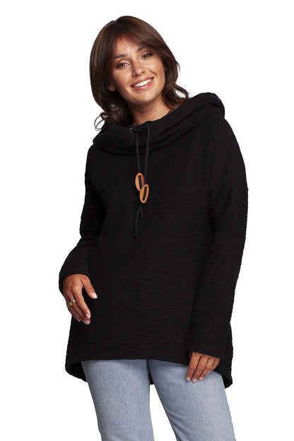 Stylish woman presenting the BeWear Oversized Cotton Blend Hooded Sweatshirt Tunic in classic black, perfect for a luxurious and warm outfit.