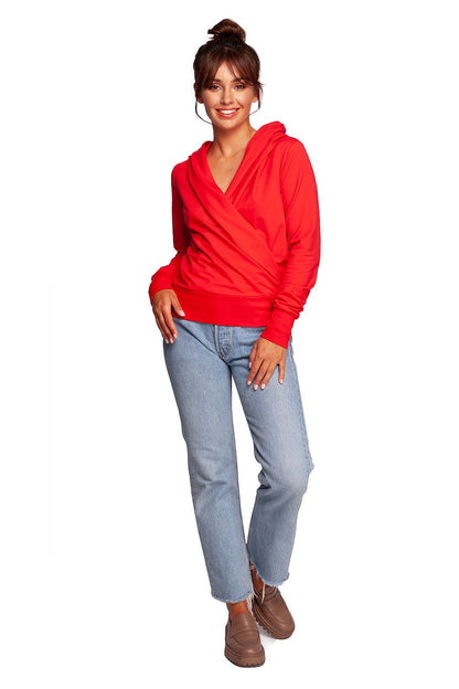 BeWear Elegant Sweatshirt With Hood, Thumb Cutouts, 92% Cotton, Slim Fit - Stylish & Unique Design, showcasing a model in a red hoodie paired with chic jeans, exuding casual luxury.