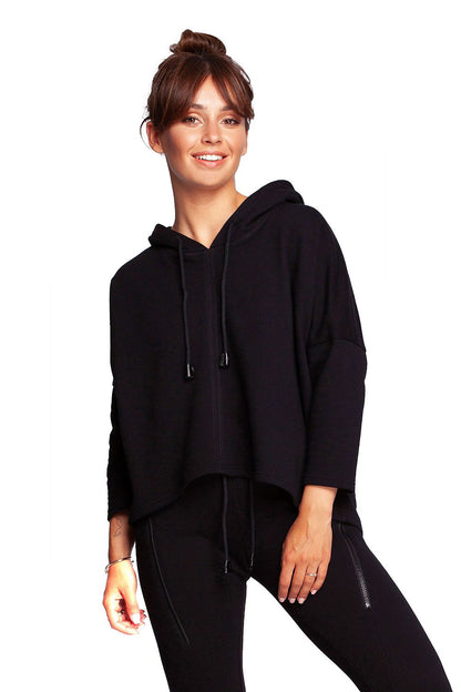 Model wearing the BeWear Loose-Fitting Trapeze Sweatshirt in Soft Knit with Hood and Faux Leather Accents in black, showcasing a chic and modern look.
