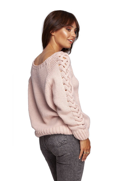 Side view of luxury fitted jumper with shoulder revealing neckline and thick plaid sleeve weave in pink, highlighting model's sophisticated styling choice.
