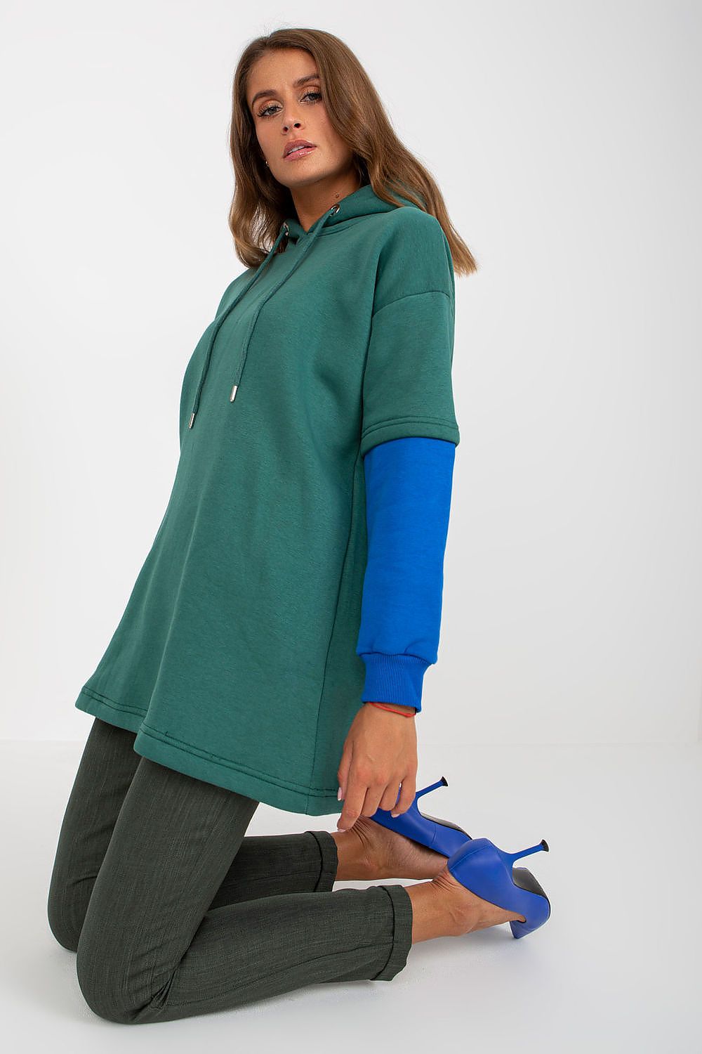 Luxury Women's Rue Paris Cotton Blend Sweatshirt with Hood, Extended Cut and Long Sleeves - Stylish model in a poised position with the elegant green hoodie and stylish blue sleeve details.