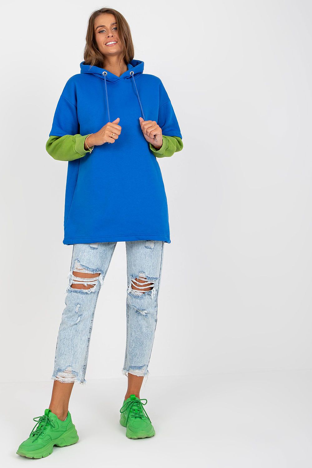 Luxury Women's Rue Paris Cotton Blend Sweatshirt with Hood, Extended Cut and Long Sleeves, displayed on a model with distressed jeans and bright green shoes.
