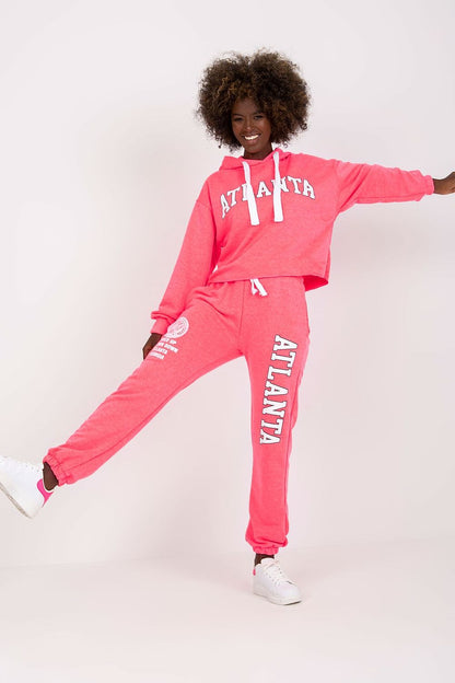 Luxury Ex Moda pink sweatshirt set, model demonstrating a hooded long sleeve top and high waist pants, complemented by stylish footwear.