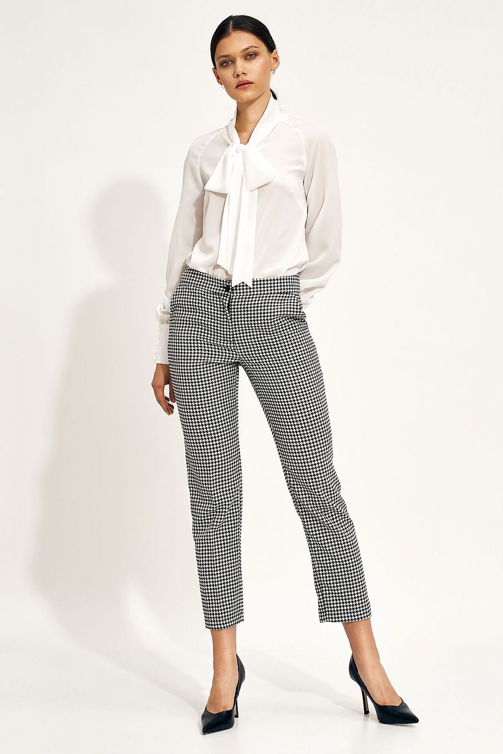 Sophisticated Nife Women's Chino Trousers with an elegant fit, featuring an elastic waistband and pockets, modelled from the front, exemplifying contemporary style with a chic blouse.
