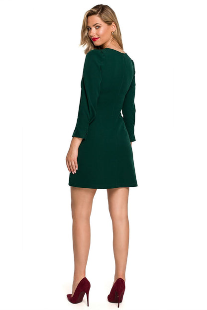 Back view of the Timeless Mini Dress with Patch Details and Elegant Pleats by Makover in green, showcasing the elegant fit and zipper styling, ideal for upscale events.
