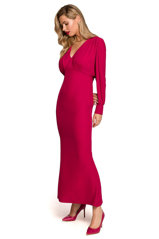 Maxi Cocktail Dress With Deep Neckline, Voluminous Sleeves And Elegant Slit By Makover, featured in a stunning fuchsia colour, showcasing a sophisticated side view of a model wearing the dress, accentuating its luxurious design.