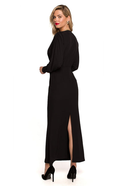 Stylish Maxi Cocktail Dress with Deep Neckline, Voluminous Sleeves and Slit by Makover, highlighting a beautiful black colour on a model from the back.