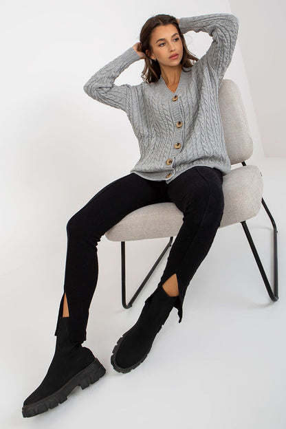 Elegant Women's Long Sleeve Acrylic Cardigan with Button Closure by Rue Paris, featuring a model in a relaxed pose, wearing a grey cardigan with a cable knit design, perfectly paired with modern black attire.