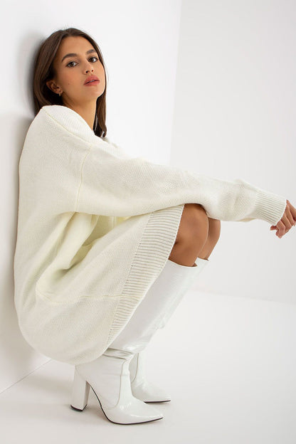 Luxurious Rue Paris Women's Sweater with Extended Cut, Long Sleeves and Heart Neckline in elegant white, worn with fashionable white knee-high boots.