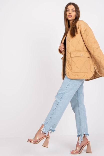 A chic view of the Rue Paris Women's Quilted Transitional Jacket in camel, elegantly worn by a model paired with distressed jeans, enhancing the outfit's overall luxury aesthetic.