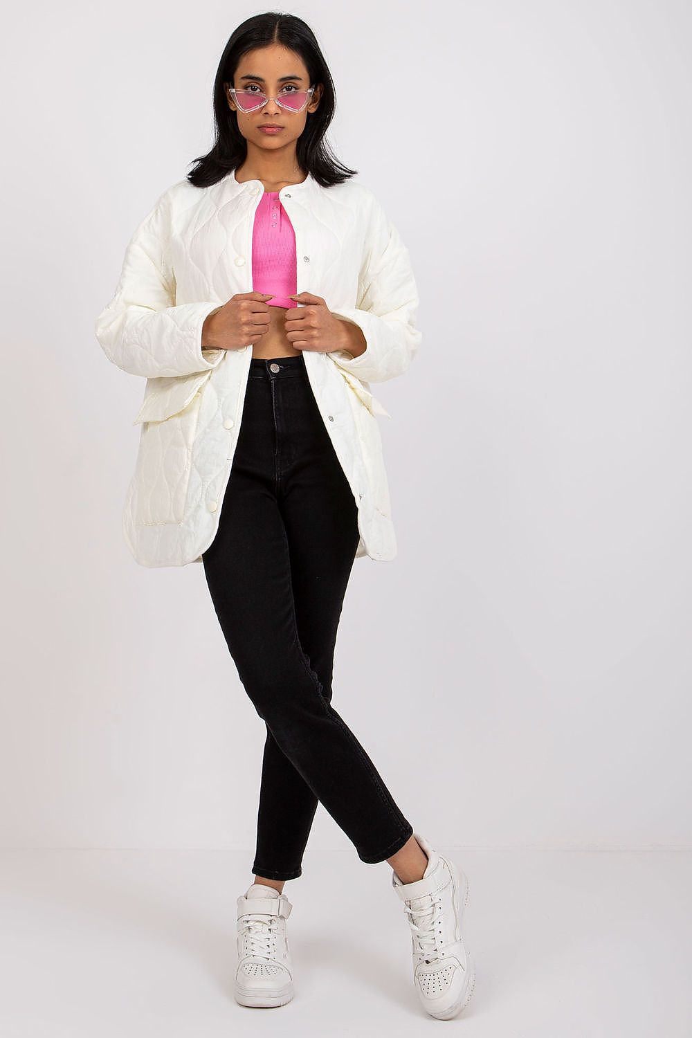 Stylish Rue Paris Women's Quilted Transitional Jacket in pristine white, paired with a vibrant pink top and black jeans, worn by a model showcasing the luxurious layering perfect for cooler days.