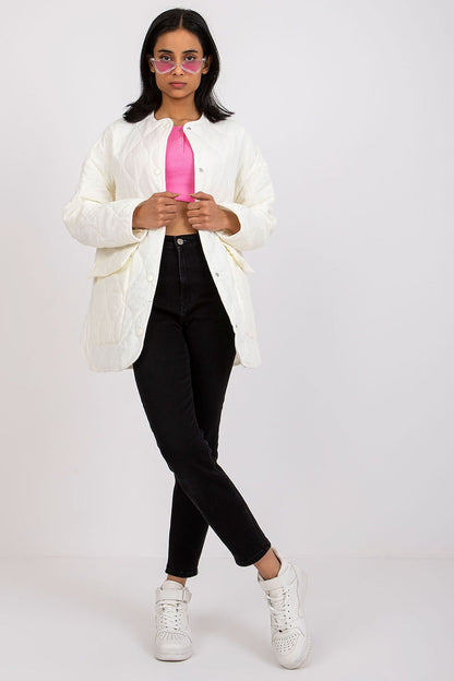 Stylish Rue Paris Women's Quilted Transitional Jacket in pristine white, paired with a vibrant pink top and black jeans, worn by a model showcasing the luxurious layering perfect for cooler days.
